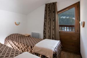 Ένα ή περισσότερα κρεβάτια σε δωμάτιο στο Lagrange Vacances Les Chalets du Mont Blanc +17 φωτογραφίες