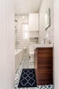 ein Badezimmer mit einem Waschbecken, einer Badewanne und einem WC in der Unterkunft Stylish 2Bedroom flat near train station in London in Seven Kings