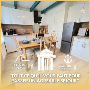eine Küche mit einem Tisch und Stühlen sowie einem Kühlschrank in der Unterkunft Le Phare du Bout du Monde - Logement proche du port in La Flotte