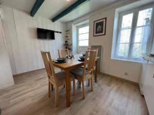 comedor con mesa de madera y sillas en Le Phare du Bout du Monde - Logement proche du port en La Flotte