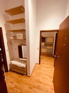 una habitación vacía con un pasillo con estanterías y suelo de madera dura en Retro Appartement im Herzen von Köln Deutz, en Colonia