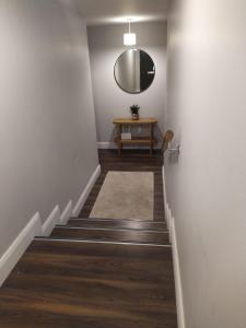 a hallway with stairs with a mirror and a table at Spacious Two bedroom City apartment Longs Place, Dublin 8 in Dublin