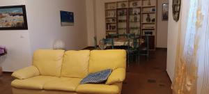 un divano giallo in soggiorno con tavolo di Sa domo manna a Porto Ottiolu