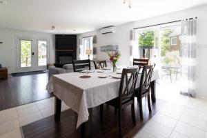 een eetkamer en een woonkamer met een tafel en stoelen bij Détente Orford 111 condo/chalet in Orford