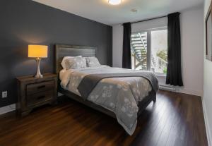 um quarto com uma cama com um candeeiro e uma janela em Détente Orford 111 condo/chalet em Orford