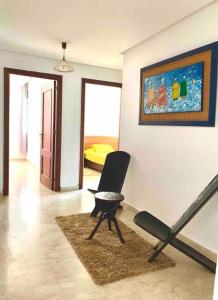 un salon avec une chaise et un tableau mural dans l'établissement Hayriad : Charmant 3 Chambres . Wifi, Smart TV, à Rabat