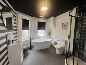 One Battison - Affordable Rooms, Suites & Studios in Stoke on Trent في ستوك أون ترينت: حمام مع حوض ومغسلة ومرحاض
