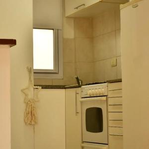 cocina con estufa blanca y ventana en tu dpto en ROSARIO, en Rosario