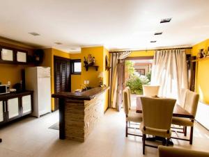 uma cozinha com paredes amarelas e uma mesa e cadeiras em Casa Felice - Canela em Canela