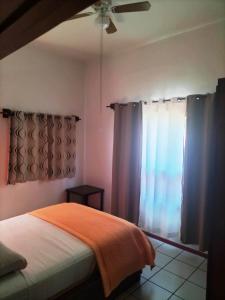 a bedroom with a bed and a ceiling fan at Adanesne Apartments in Ensenada