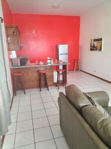 a living room with a couch and a red wall at Adanesne Apartments in Ensenada