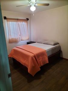 um quarto com uma cama com um cobertor laranja em Adanesne Apartments em Ensenada