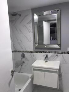 Baño blanco con lavabo y espejo en Parque España en Rosario