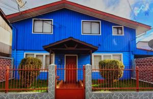 una casa azul con una puerta roja en HOSTAL PARADISE BLUE OSORNO en Osorno