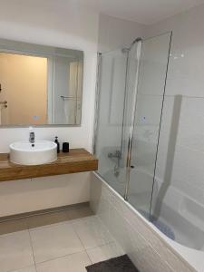 uma casa de banho branca com um lavatório e um chuveiro em Paradise Garajau em Garajau
