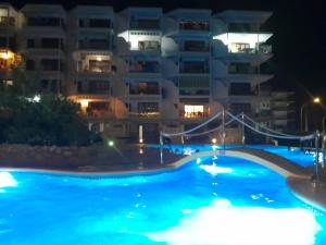a swimming pool in front of a building at night at MIMOSAS VISTAS in Miami Platja