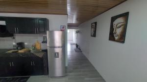 cocina con nevera de acero inoxidable y pasillo en Casa Dñ Ana, en Jacó