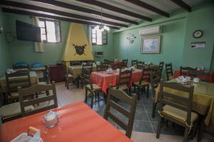 a restaurant with tables and chairs in a room with green walls at Apart Hotel Géminis in Termas del Daymán