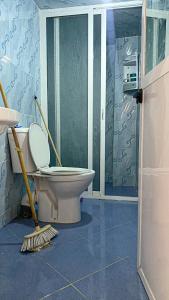 La salle de bains est pourvue de toilettes et d'un balai. dans l'établissement شاطئ الهدوء أمتار - استأجر كوخ محمد الربون ليوم من الاسترخاء, 