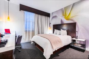 a hotel room with a large bed and a desk at O Hotel by LuxUrban, Trademark Collection by Wyndham in Los Angeles