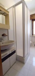 uma cozinha branca com um lavatório e uma porta de vidro deslizante em Casa vancanze con camino em Castel di Sangro