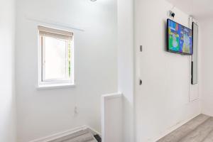 a white room with a window and a television on a wall at Birmingham Great Barr Property Near Junction 7 M6 in Birmingham