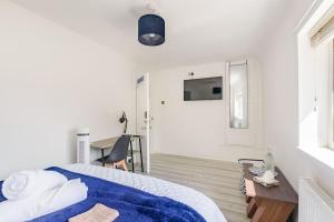 a white bedroom with a blue blanket on a bed at Birmingham Great Barr Property Near Junction 7 M6 in Birmingham