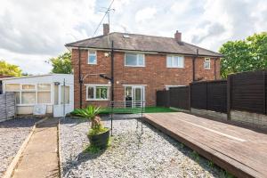 une maison en briques avec une terrasse en bois devant elle dans l'établissement Birmingham Great Barr Property Near Junction 7 M6, à Birmingham