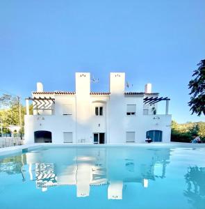 a villa with a swimming pool in front of a house at CASAS NAS TERMAS in Cabeço de Vide