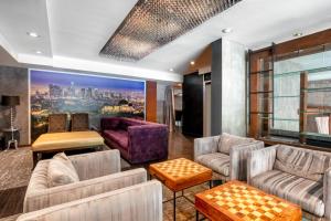 a living room with couches and a painting of a city at O Hotel by LuxUrban, Trademark Collection by Wyndham in Los Angeles