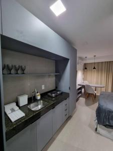 a kitchen with a sink and a table in a room at Flat em Boa Viagem 100% Equipado in Recife