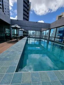 a swimming pool on the roof of a building at Flat em Boa Viagem 100% Equipado in Recife