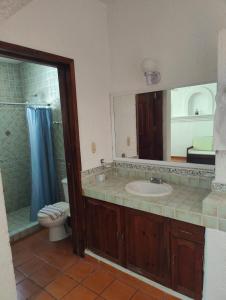 uma casa de banho com um lavatório, um WC e um espelho. em Villa Isabel em Tangolunda