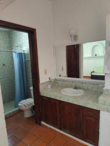 y baño con lavabo, aseo y espejo. en Villa Isabel en Tangolunda