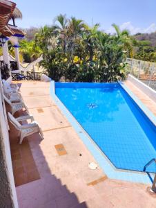 a swimming pool with chairs next to a resort at Villa Isabel in Tangolunda