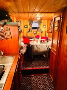 uma cozinha e sala de estar com uma mesa num trailer em Magnifique péniche remorqueur à louer em Évran