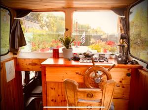 uma cozinha com uma secretária de madeira e uma janela em Magnifique péniche remorqueur à louer em Évran