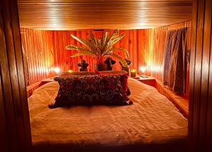 Un dormitorio con una cama grande con una planta. en Magnifique péniche remorqueur à louer, en Évran