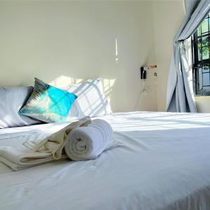 una cama blanca con una toalla puesta en Boca Simon Vacation Curacao en Willemstad