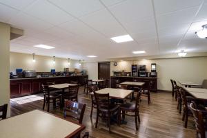 a dining room with tables and chairs and a kitchen at Best Western Bemidji in Bemidji