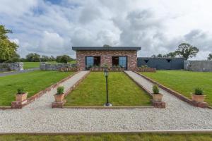 a stone house with a garden in front of it at 'The Stables' (Tigh Johnny Mór) in Galway