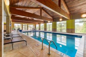 a large swimming pool with blue water in a building at Best Western Plus Eau Claire Conference Center in Eau Claire