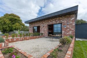 una casa de ladrillo con un patio delante en 'The Stables' (Tigh Johnny Mór) en Galway