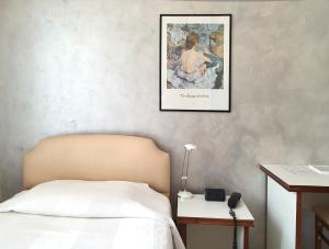 um quarto com uma cama e uma fotografia na parede em Hotel Molise 2 em Milão
