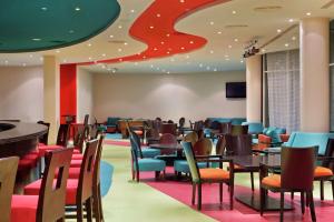 DoubleTree by Hilton Sharks Bay Resort في شرم الشيخ: مطعم بطاولات وكراسي وسقف احمر