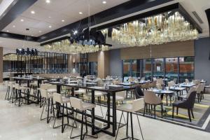 a restaurant with tables and chairs and chandeliers at Hilton Istanbul Bakirkoy in Istanbul