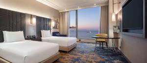 a hotel room with two beds and a large window at Hilton Istanbul Bakirkoy in Istanbul