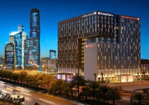 a tall building in a city at night at Hilton Garden Inn Riyadh Financial District in Riyadh