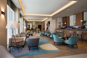 a hotel lobby with chairs and tables and a bar at Hilton Garden Inn Riyadh Financial District in Riyadh
