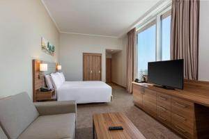 a hotel room with a bed and a flat screen tv at Hilton Garden Inn Riyadh Financial District in Riyadh